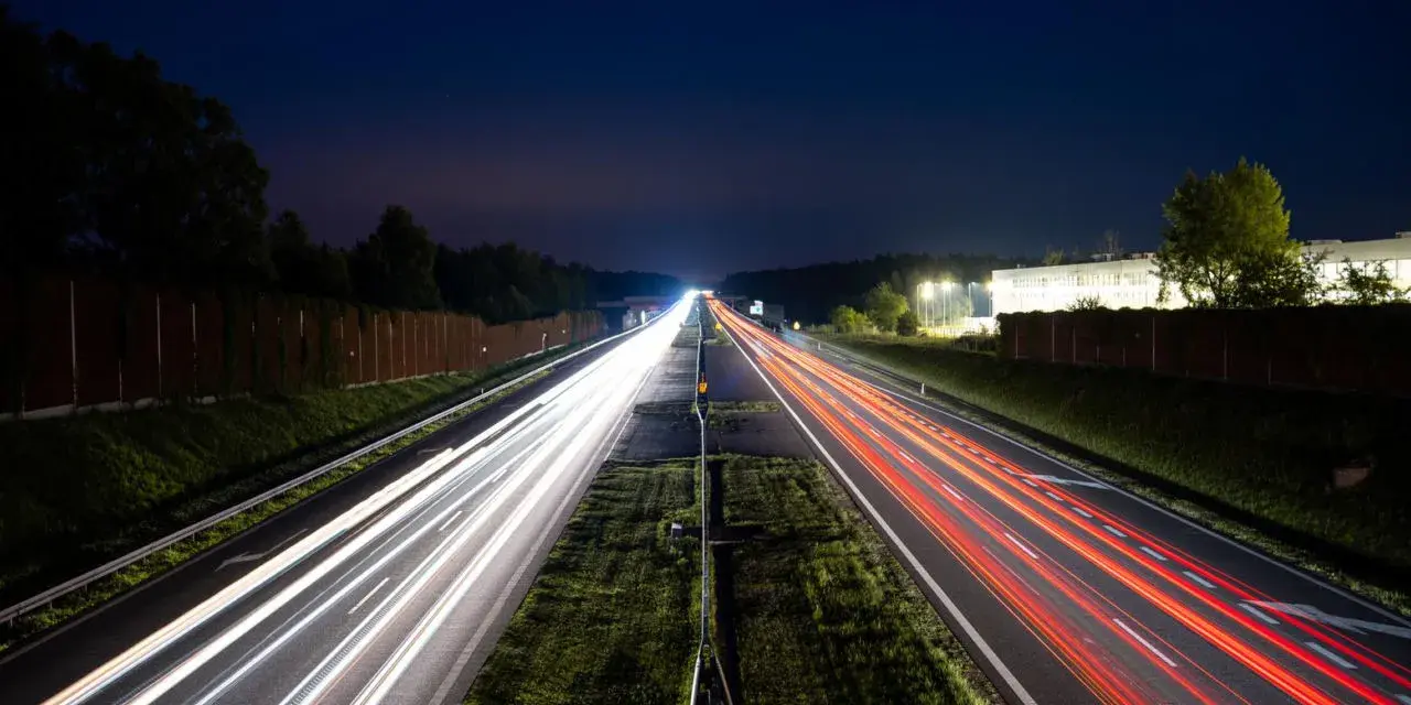 Nocne smugi świateł samochodów na autostradzie A4 między Katowicami a Krakowem. Opłaty za przejazd nie zatrzymują ruchu.