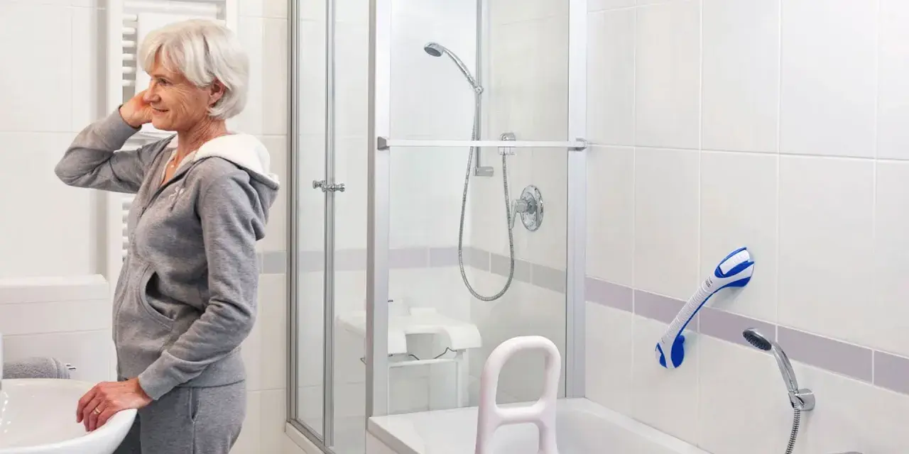 Une femme se prépare dans une salle de bain équipée d'une barre d'appui PMR norme pour plus de sécurité.