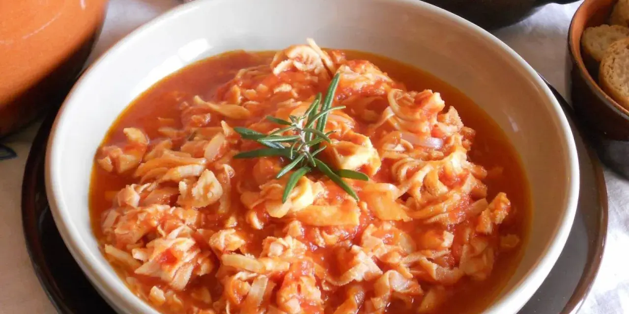 Trippa ricetta della nonna in un piatto bianco, guarnita con rosmarino. Un classico sapore di casa.