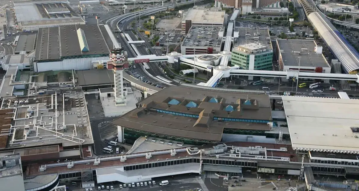 Widok z lotu ptaka na lotnisko Bergamo. Widać terminale, wieżę kontroli lotów, drogi kołowania i parkingi.
