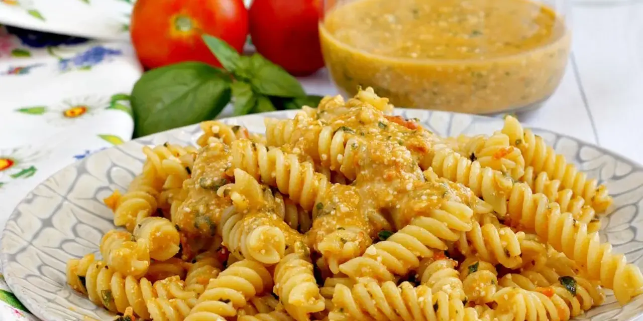Fusilli conditi con una cremosa salsa di ricotta e pomodorini, guarniti con basilico fresco.