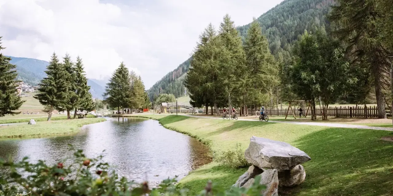 Passeggiata in bici ai laghetti di San Leonardo, tra alberi e montagne.