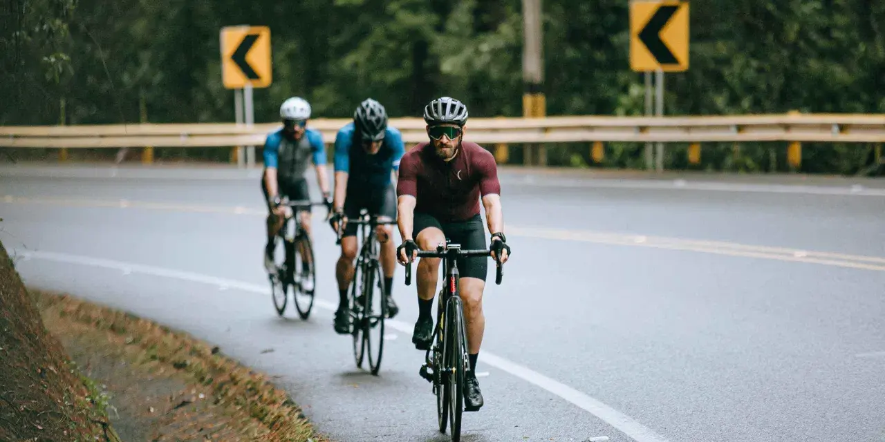 Cyclists on a wet road, navigating curves, embodying the stress recovery adaptation cycle.