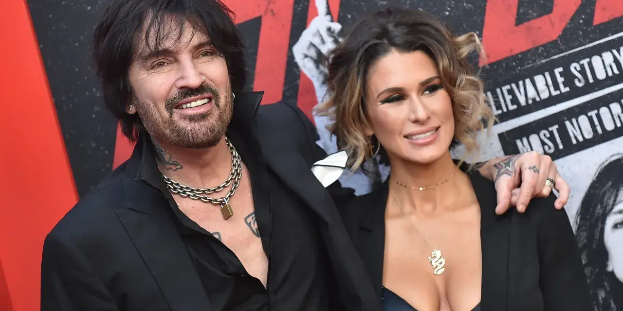 Tommy Lee i jego żona, Brittany Furlan, uśmiechają się do aparatu na czerwonym dywanie.