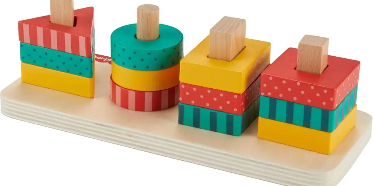 Kolorowe klocki Fisher Price w kształcie trójkąta, walca i kwadratów na drewnianej podstawie.