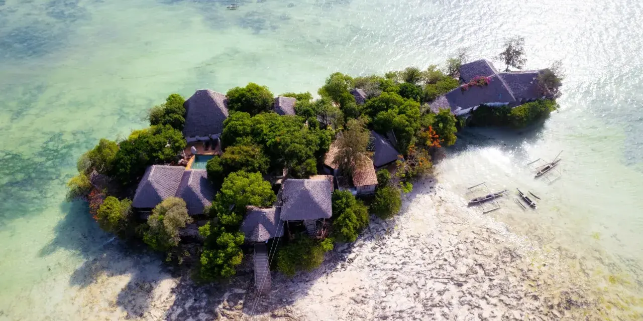 Rajska wyspa z chatkami i basenem, otoczona turkusową wodą. Idealne zanzibar atrakcje dla szukających spokoju.