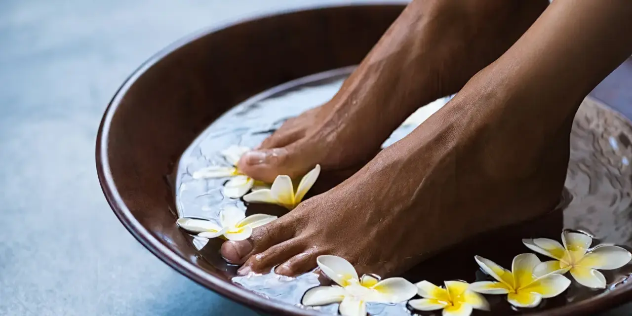 Relaxing foot bath with frangipani flowers. The amount of epsom salt in a foot bath can vary, but a common recommendation is 1/2 cup per gallon of water for a soothing soak.