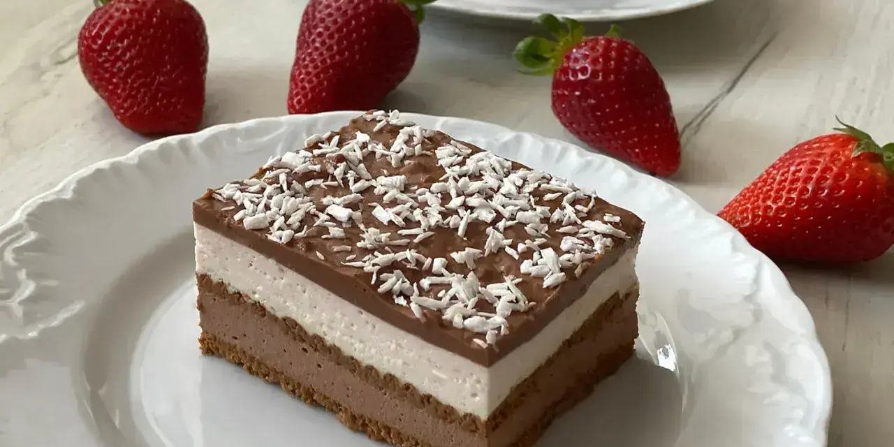 Szybkie ciasto z serkiem mascarpone, warstwowe, z polewą czekoladową i wiórkami kokosowymi, ozdobione świeżymi truskawkami.