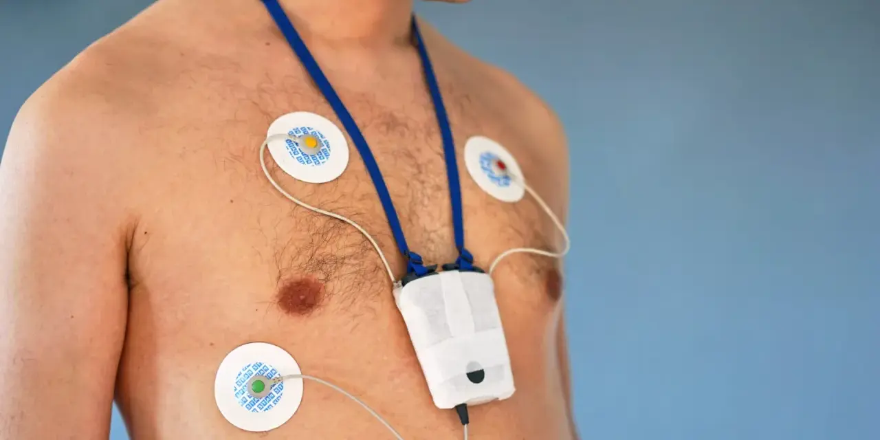 Mężczyzna z elektrodami EKG na klatce piersiowej i urządzeniem do badania holtera. Unikaj wysiłku fizycznego podczas badania holtera.