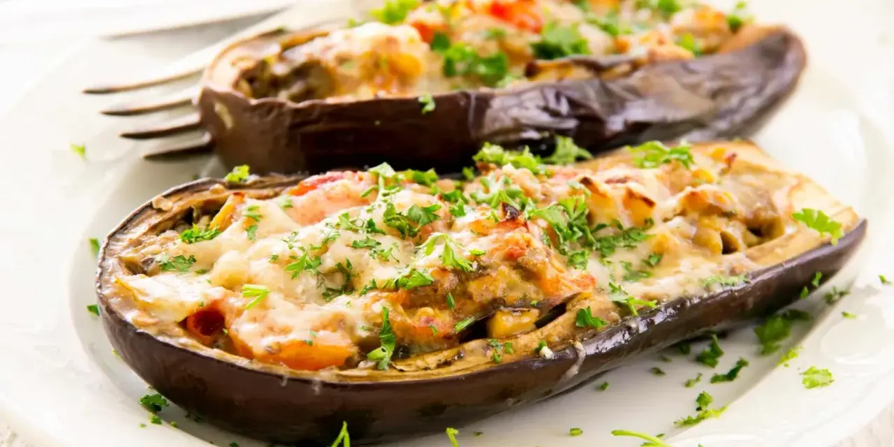 Berenjenas rellenas de carne picada, gratinadas con queso y perejil fresco. Un plato casero y delicioso.