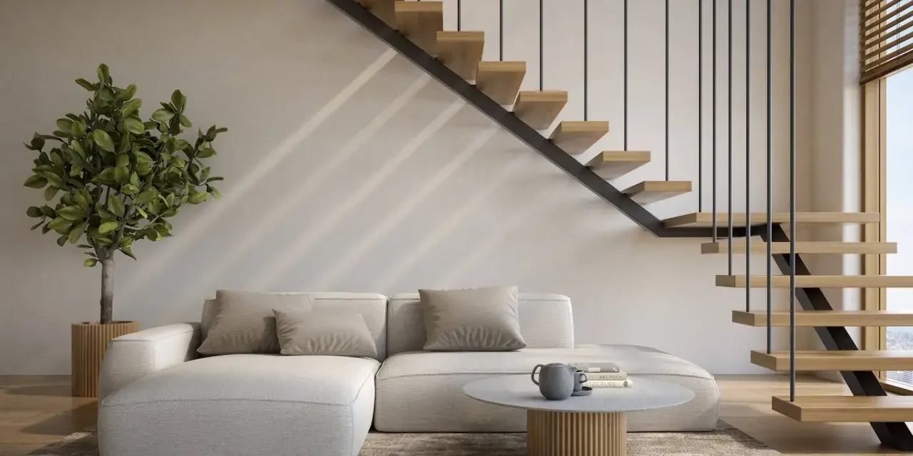 Nowoczesne schody w salonie, z drewnianymi stopniami i czarną balustradą, prowadzą do wyższych kondygnacji. Obok wygodna kanapa i stolik kawowy.