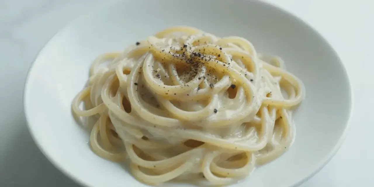 Pyszny makaron z pieprzem, kremowy sos otula złociste spaghetti, posypane świeżo mielonym pieprzem.