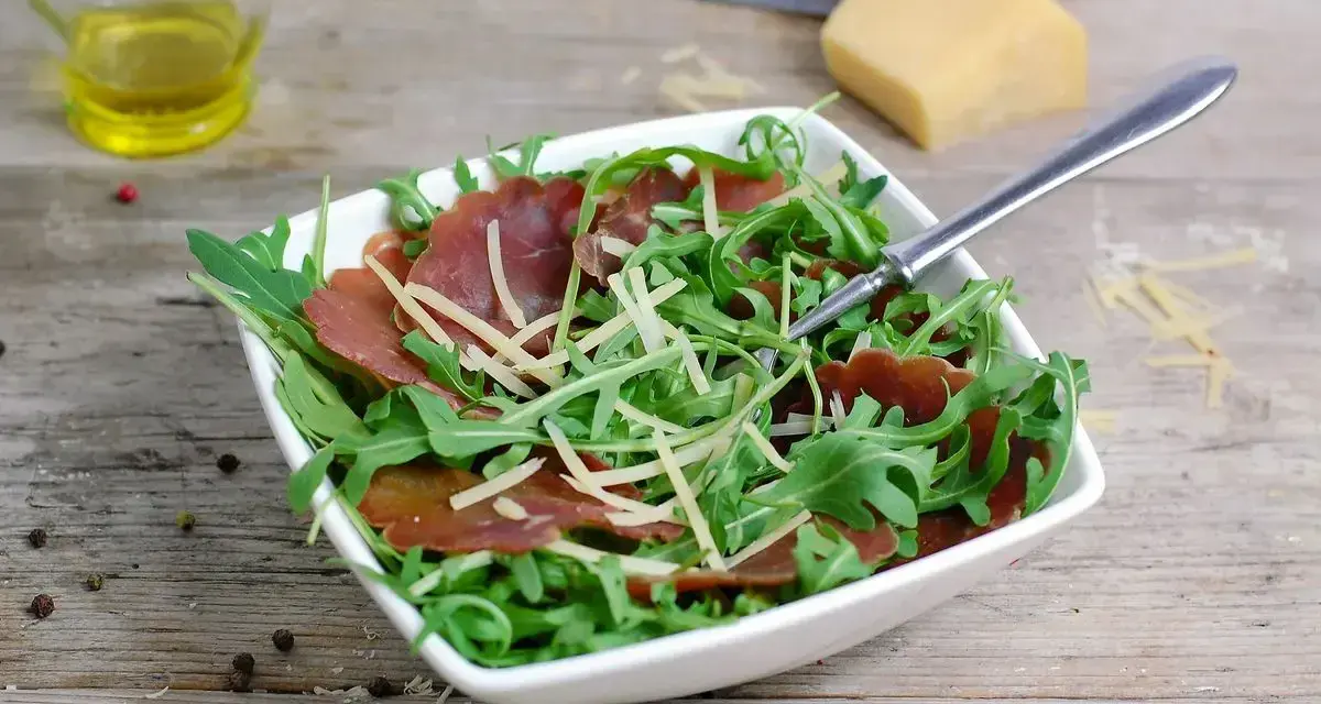 Insalata fresca con bresaola rucola e grana, condita con olio d'oliva e pepe.