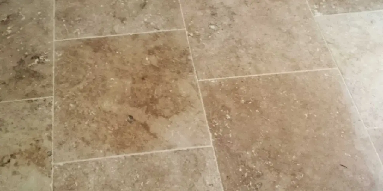 Détail d'un sol en travertin, montrant les variations de couleur et de texture. Ce traitement travertin met en valeur la beauté naturelle de la pierre.