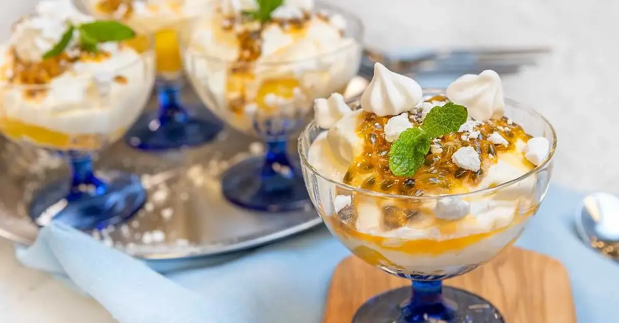 Fluffig Eton Mess med passionsfrukt och maräng i glasbägare. En härlig dessert som smälter i munnen.