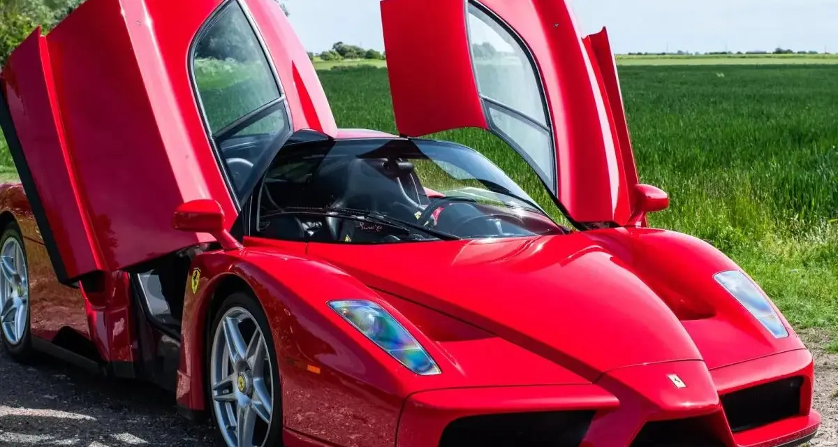 Czerwone Ferrari Enzo z otwartymi drzwiami, marzenie wielu. Zastanawiasz się, ferrari enzo ile kosztuje?