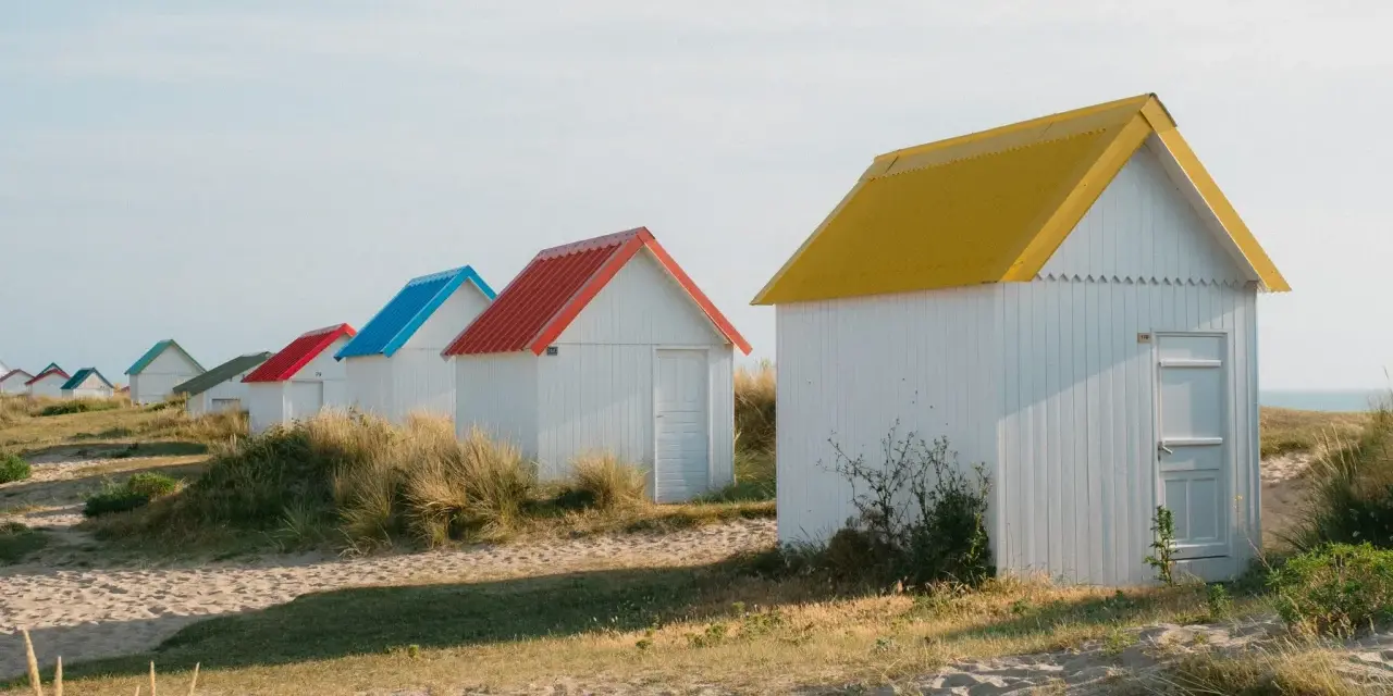 Cabanes de plage colorées à Gouville-sur-Mer : découvrez les activités nautiques et les promenades sur le sable.