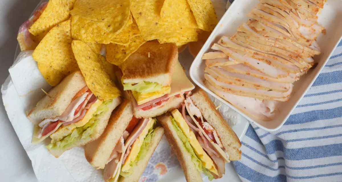 Sandwiches de fiambre de pollo casero, papas fritas y lonchas de pollo. ¡Un festín listo para disfrutar!