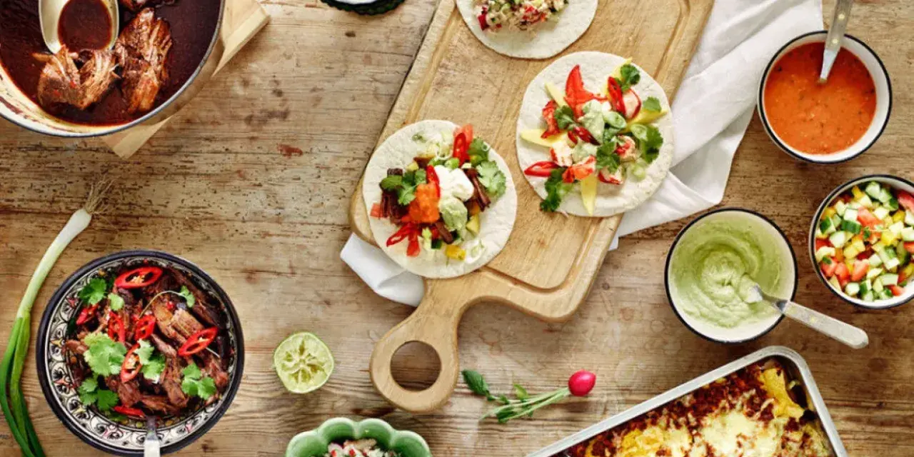 En härlig dukning med tacos, gryta med kött, salsa och guacamole. Perfekt för en mysig kväll med vin till tacos.