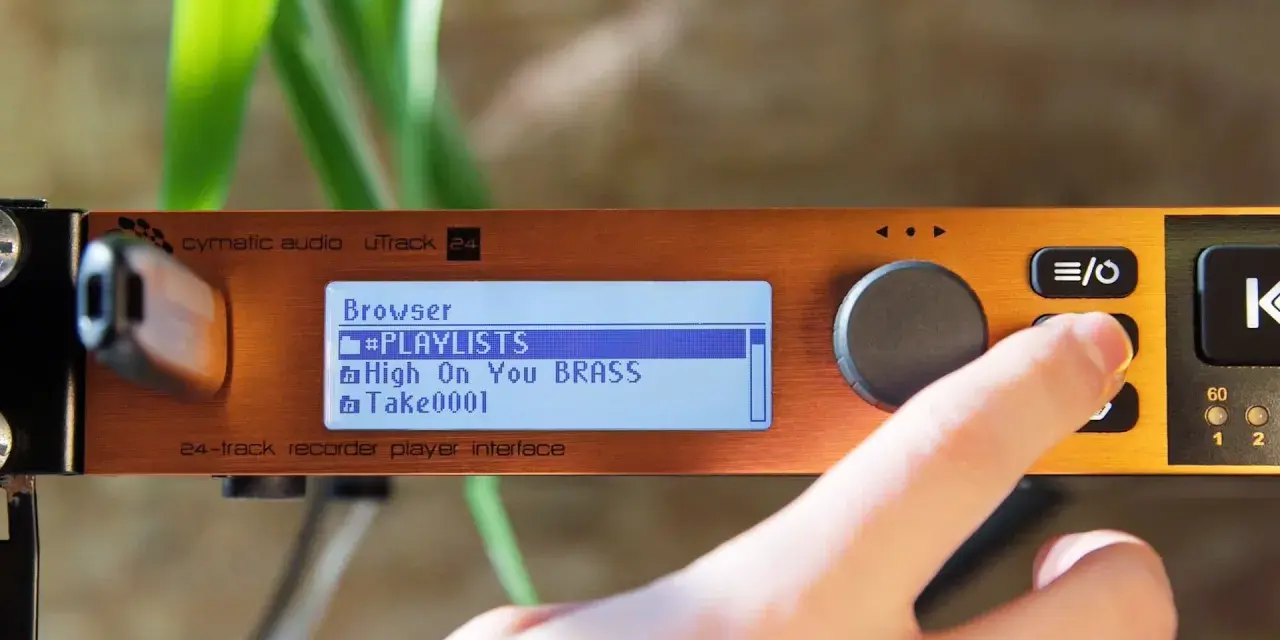 Palec naciska przycisk na urządzeniu cymatic audio uTrack 24, wyświetlającym listę odtwarzania.