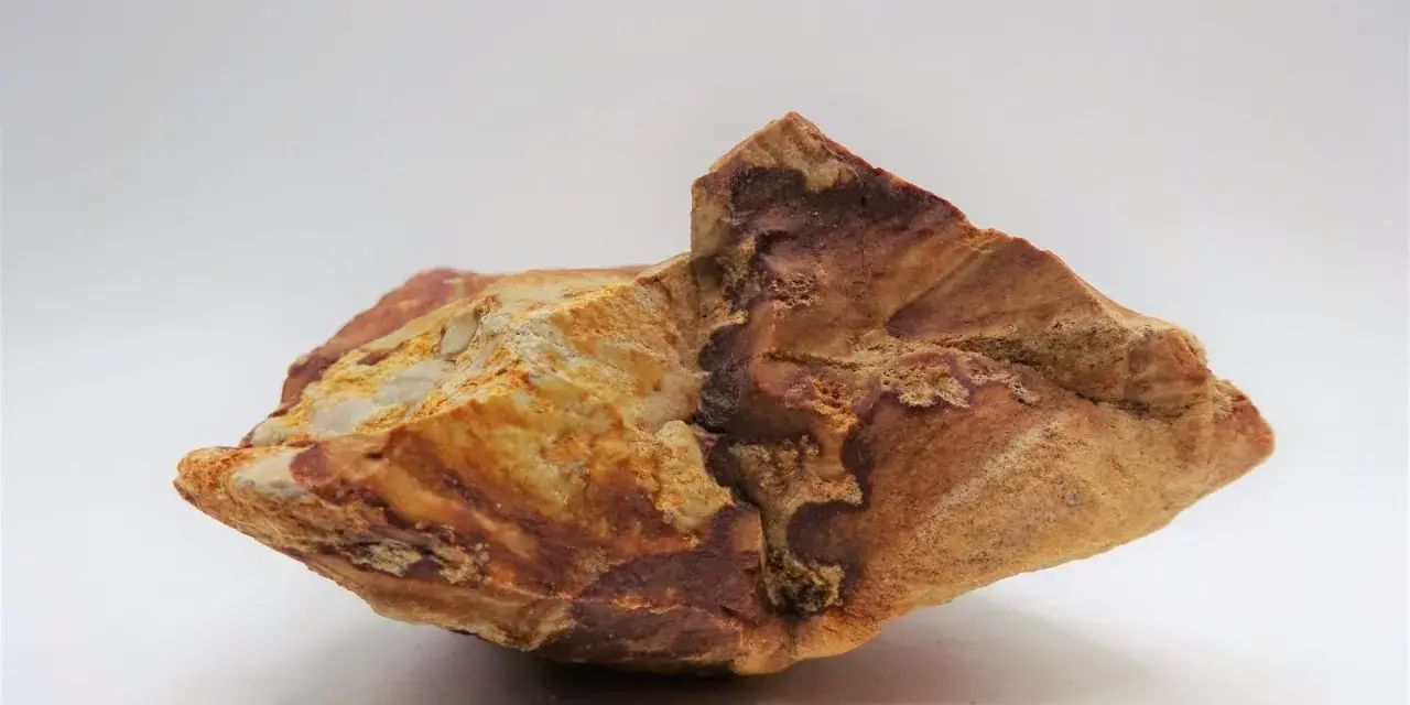 Fragmento de jaspe con vetas rojizas y ocres, mostrando sus propiedades terrosas y su belleza natural.