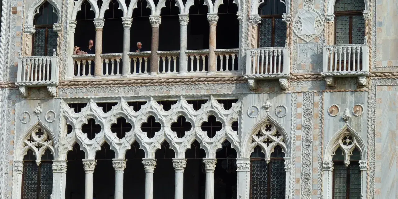 Dettaglio del **Palazzo Cadoro** con le sue finestre a trifora e balconi ornati. Persone osservano dal primo piano.