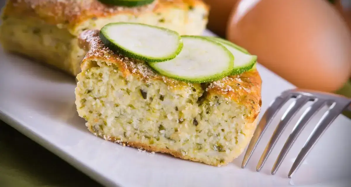 Saporito sformato di zucchine, guarnito con fette di zucchina fresca e una spolverata di parmigiano. Perfetto per un pasto leggero.