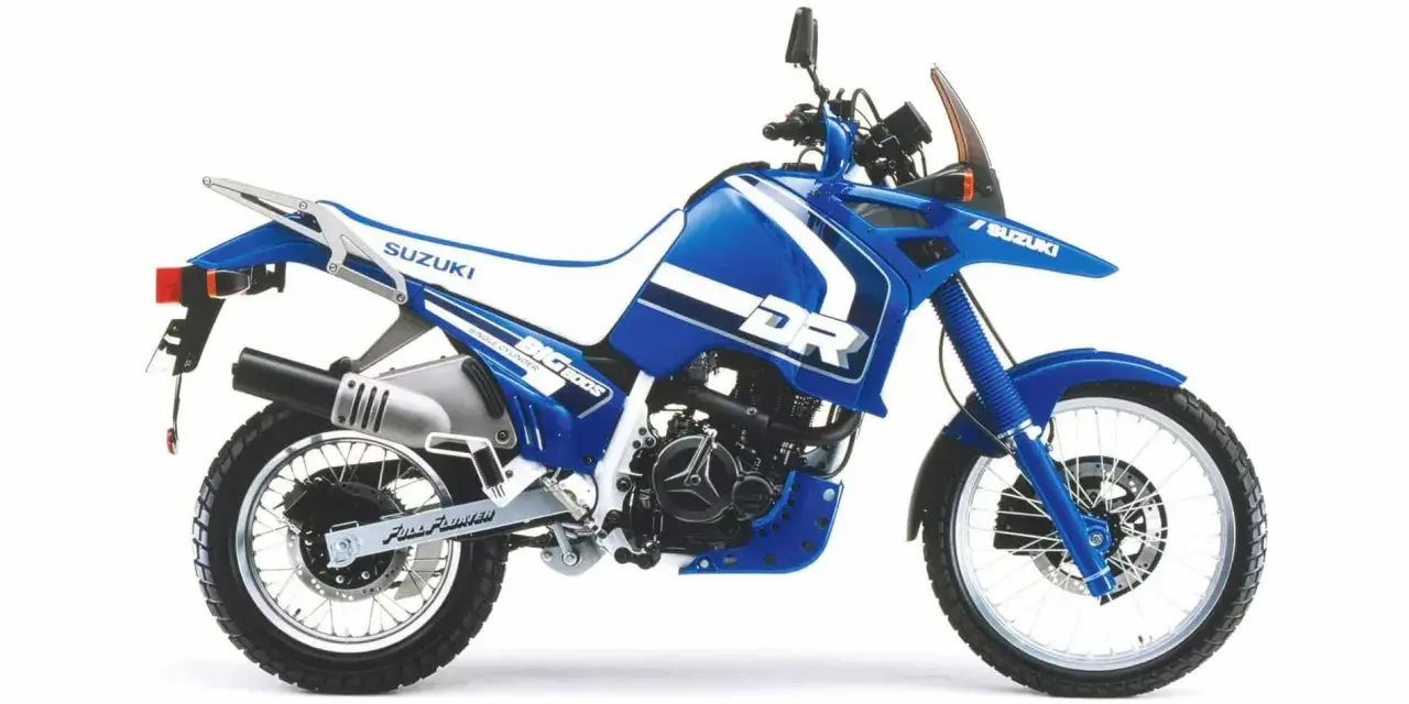 Niebieski motocykl Suzuki DR 800 BIG z białymi akcentami, gotowy na przygodę.