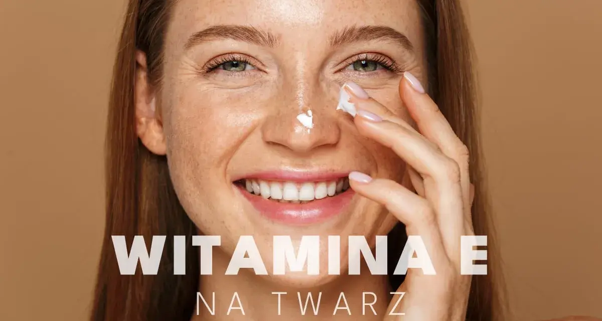 Uśmiechnięta kobieta z piegami aplikuje krem pod oczy. Witamina E na twarz dla promiennej cery.
