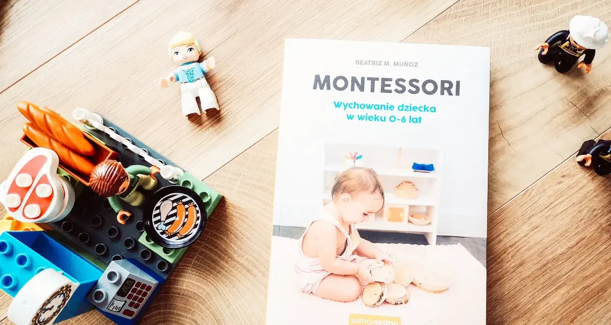 Książka "Montessori. Wychowanie dziecka w wieku 0-6 lat" obok klocków i figurek. Idealna do nauki przez zabawę.