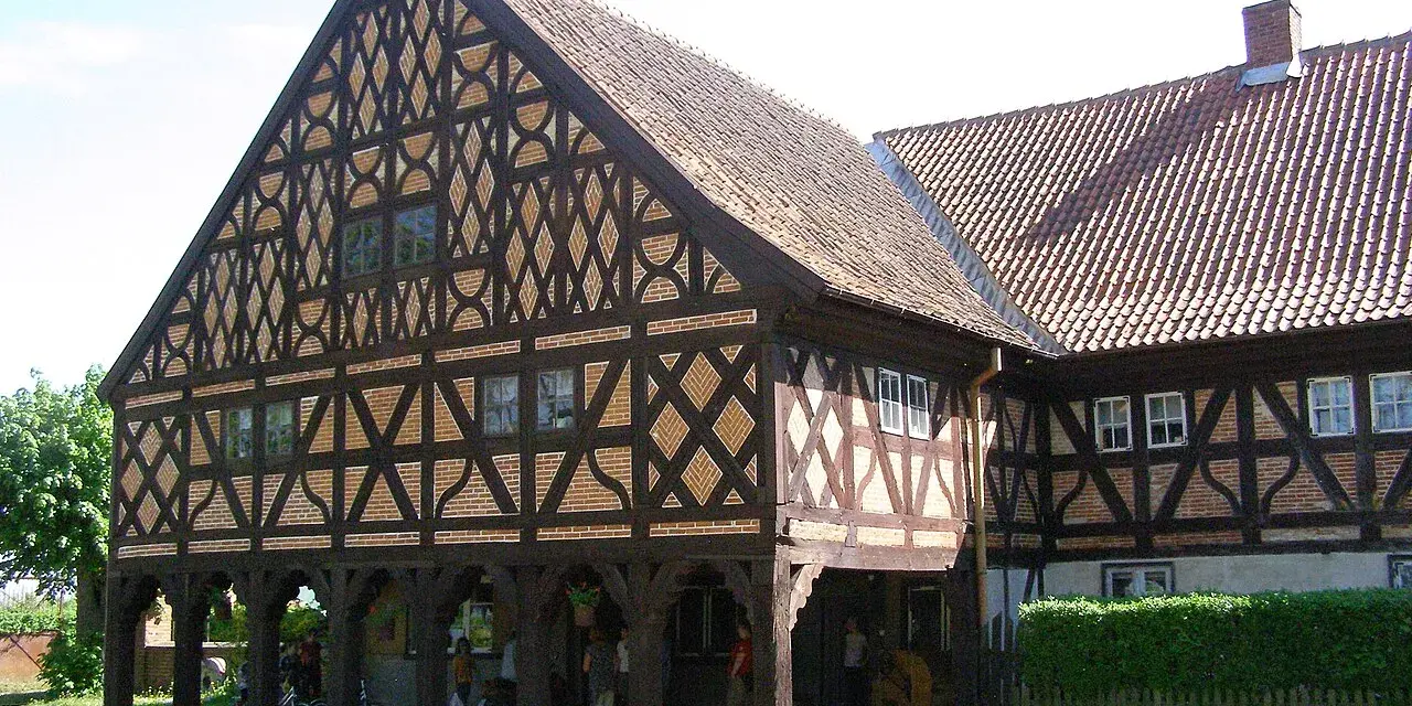 Piękny dom podcieniowy z charakterystyczną, zdobioną szachulcową fasadą i ceramicznym dachem.