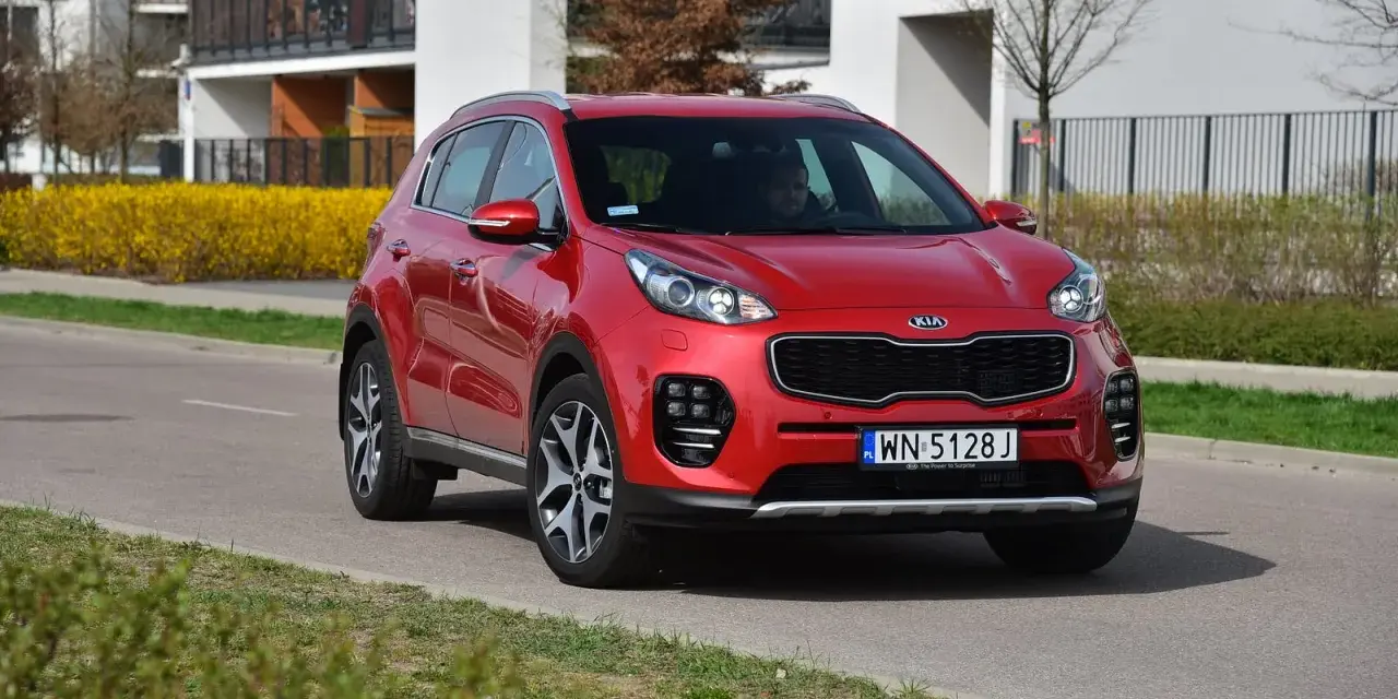 Czerwony Kia Sportage 4 na drodze, gotowy do wymiany żarówki.