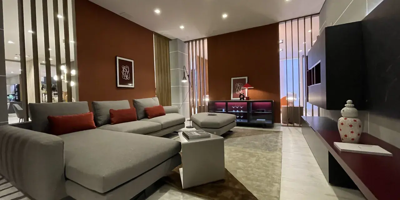 Soggiorno moderno con pareti color terracotta e divano grigio. Effetti pittura pareti moderne che creano un'atmosfera calda e accogliente.