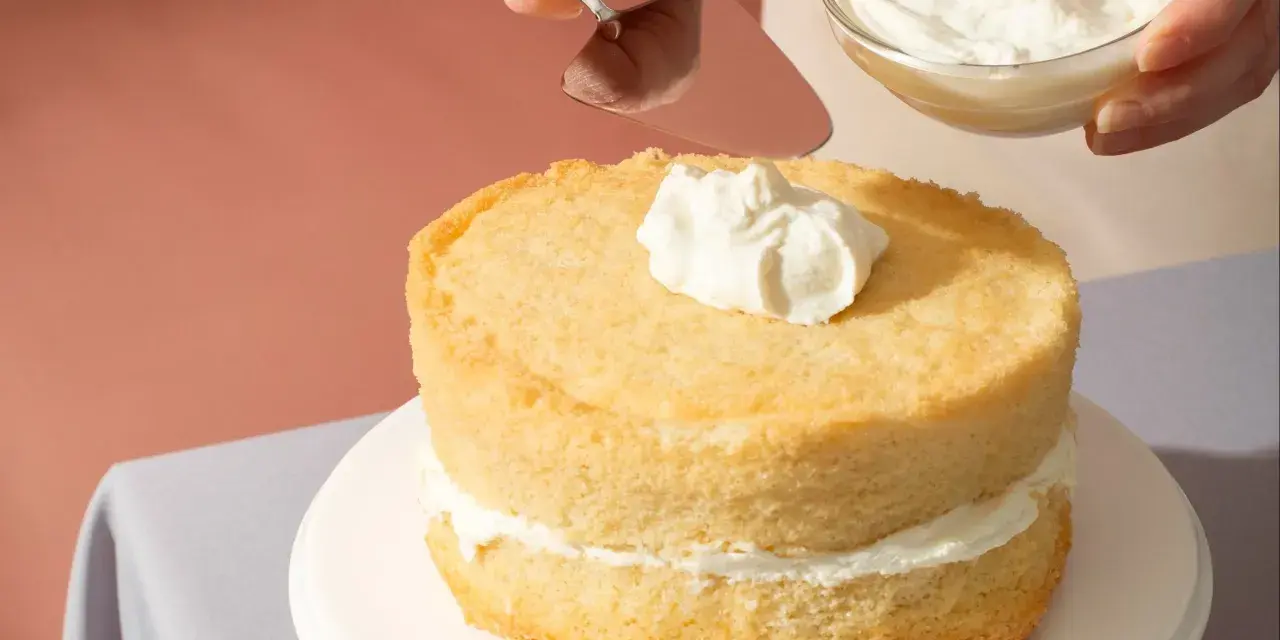 Nakładanie puszystego kremu na biszkoptowe ciasto z mascarpone.