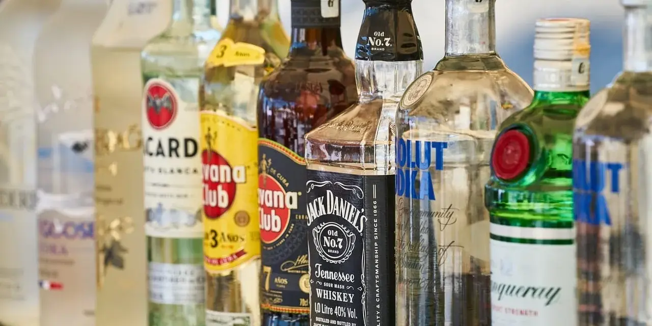 Szereg butelek alkoholi: wódka, rum, whisky, gin. Idealne do shotów warstwowych kontra shoty mieszane.