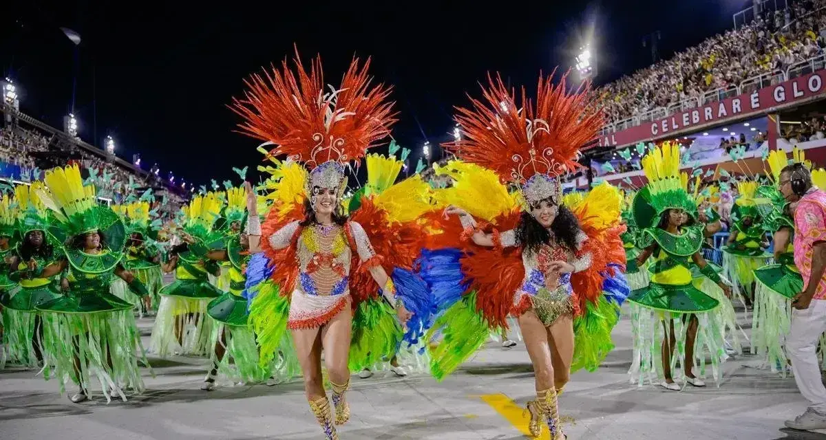 Tancerki w barwnych strojach z piórami na tle tłumu na **Rio de Janeiro karnawał**.