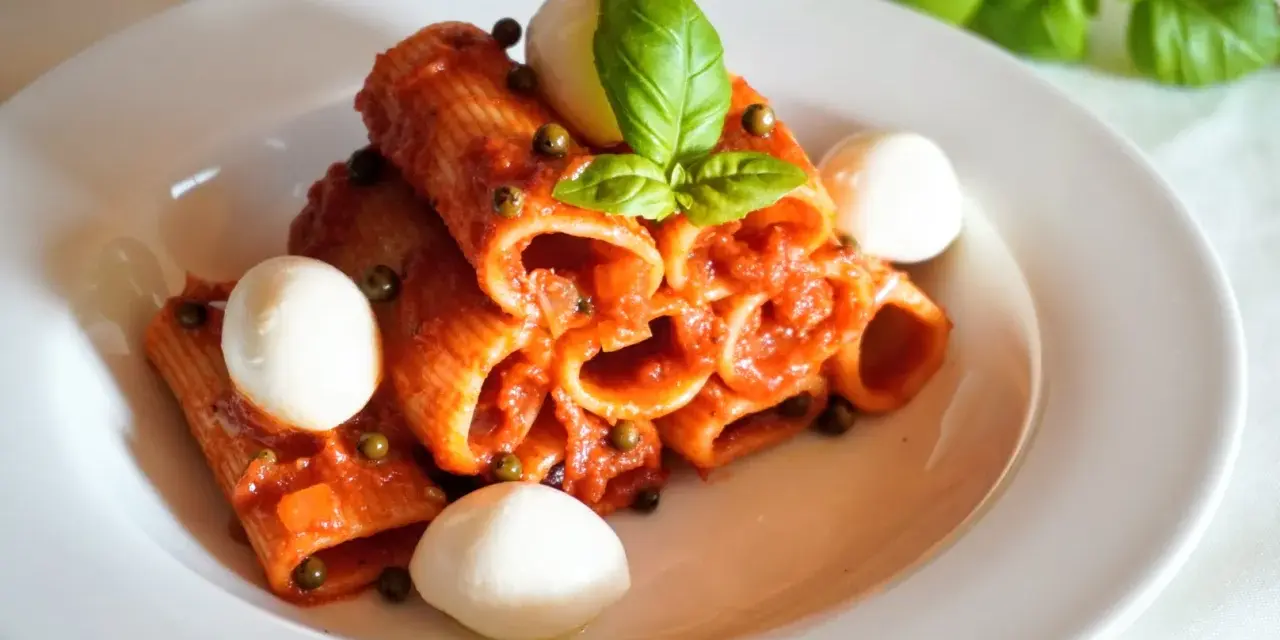 Rigatoni z sosem pomidorowym, kulkami mozzarelli i bazylią. Szybki obiad z makaronem z czerwonym pesto ze słoika.
