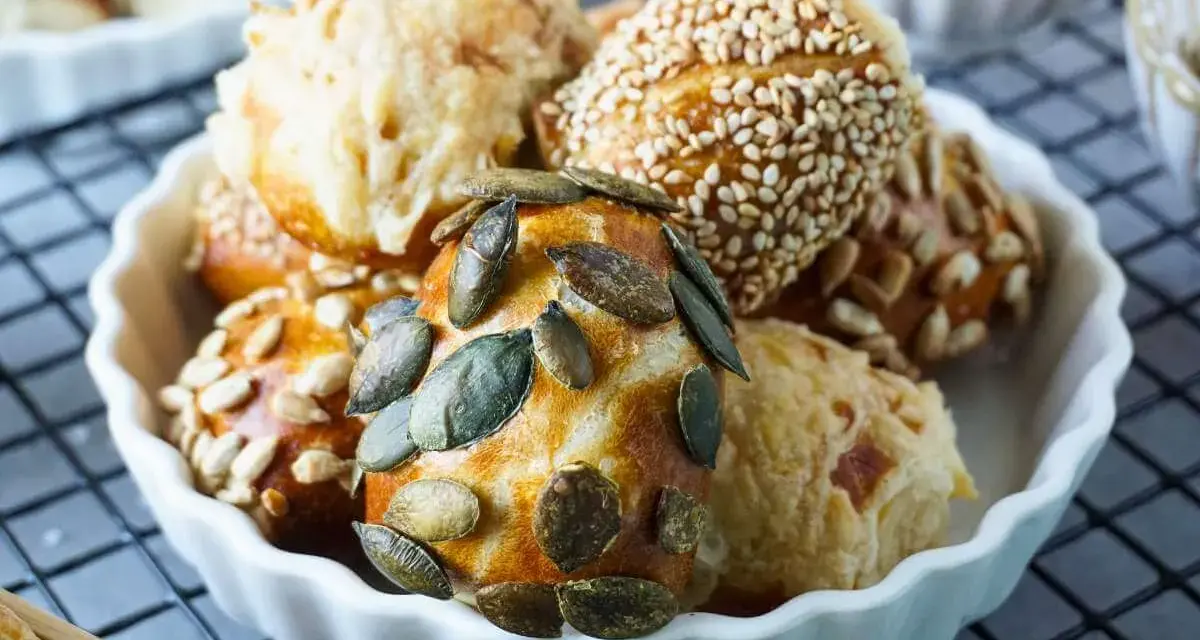 Köstliche laugen konfekt mit Kürbiskernen, Sonnenblumenkernen und Sesam in einer weißen Schale.