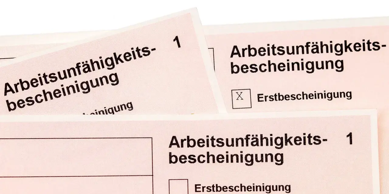 Arbeitsunfall krankschreibung unterbrochen: Mehrere Arbeitsunfähigkeitsbescheinigungen liegen übereinander. Eine Folgebescheinigung ist angekreuzt.