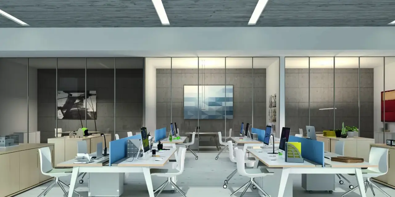 Ufficio moderno con scrivanie operative, divisori blu e sedie bianche. La disposizione segue la normativa per un ambiente di lavoro funzionale.