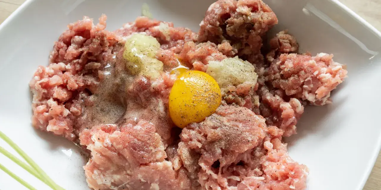 Mielone mięso z dodatkiem cebuli i jednego jajka, gotowe do dalszego przygotowania. Ile jajek do mielonych? Zazwyczaj jedno na pół kilograma mięsa.