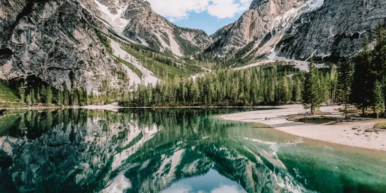 Jezioro w Dolomitach, Włochy. Odbicie gór i lasu w krystalicznie czystej wodzie. Niezwykłe walory przyrodnicze Włoch.