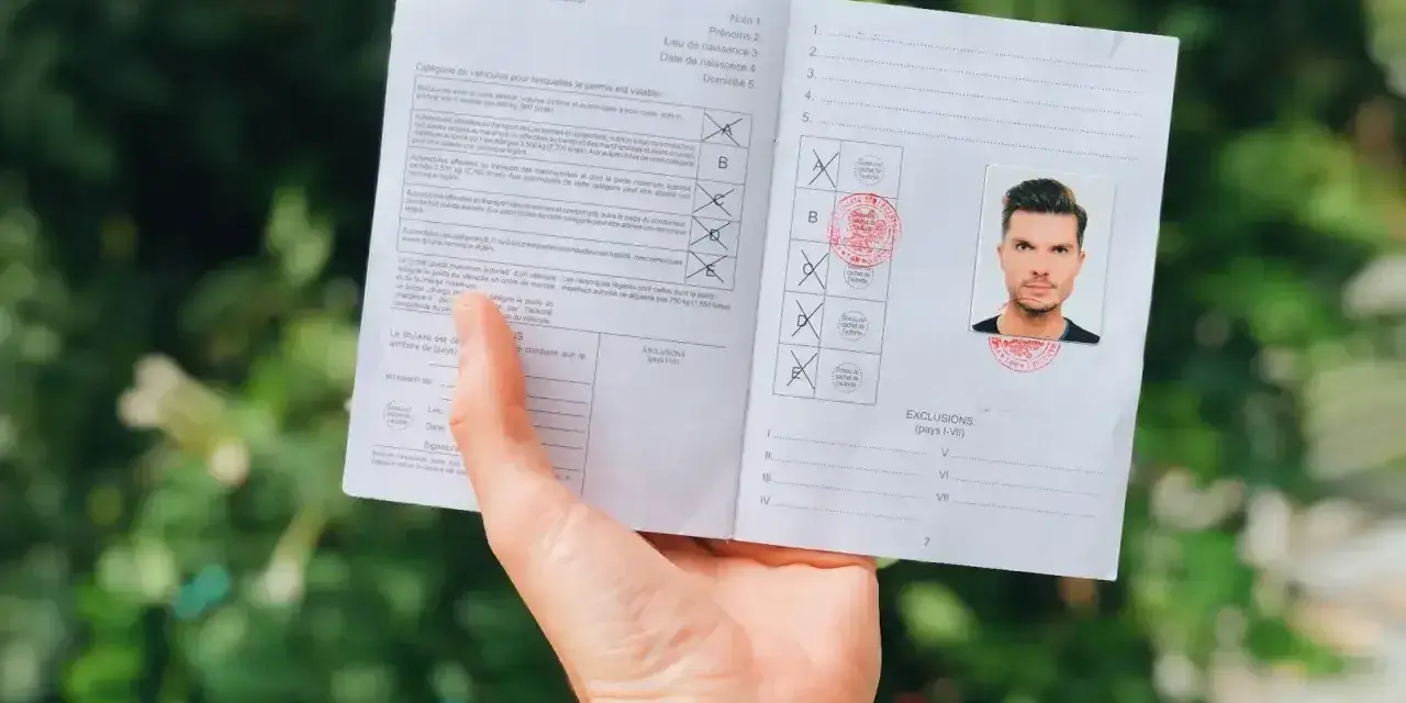 Dokument z fotografią i pieczęciami, pokazujący jak wyrobić międzynarodowe prawo jazdy.