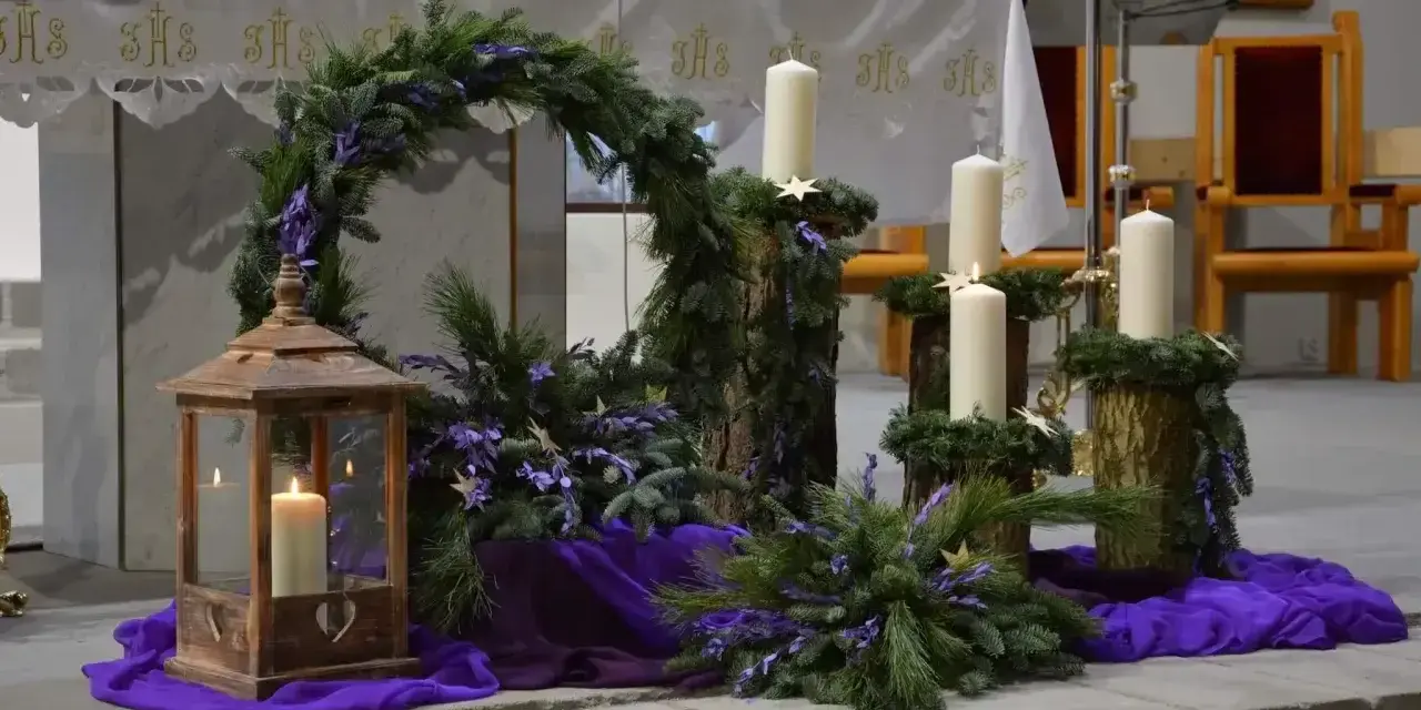 Piękny adwentowy wystrój w kościele: wieniec z gałązek, świece i fioletowe ozdoby. Dekoracje adwentowe tworzą uroczysty nastrój.