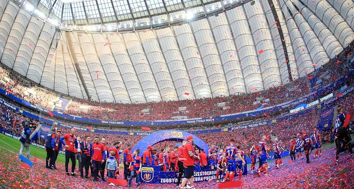 Piłkarze świętują zdobycie STS Pucharu Polski na murawie stadionu, zasypani czerwonymi konfetti.