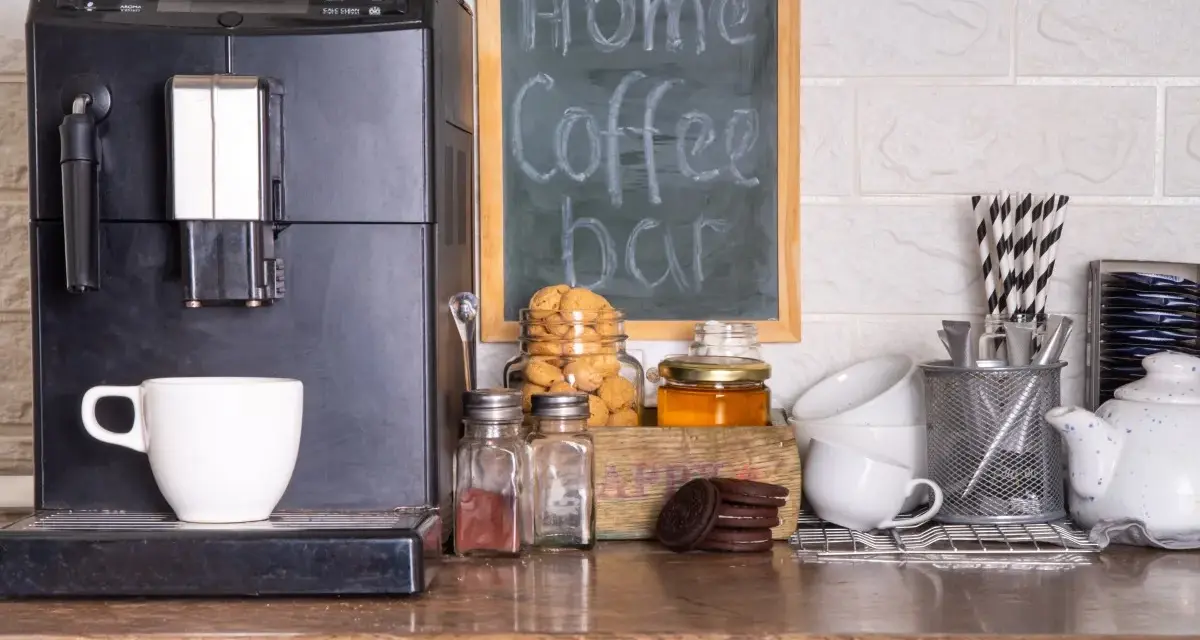 Máquina de café, taza, galletas y un letrero que dice "my Home Coffee bar". Todo listo para disfrutar de un momento de relax en tu zona de cafe en la cocina.