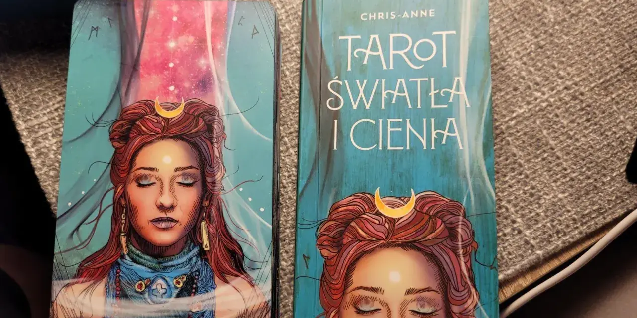 Karty i książka "Tarot Światła i Cienia" z wizerunkiem kobiety z księżycem na czole.