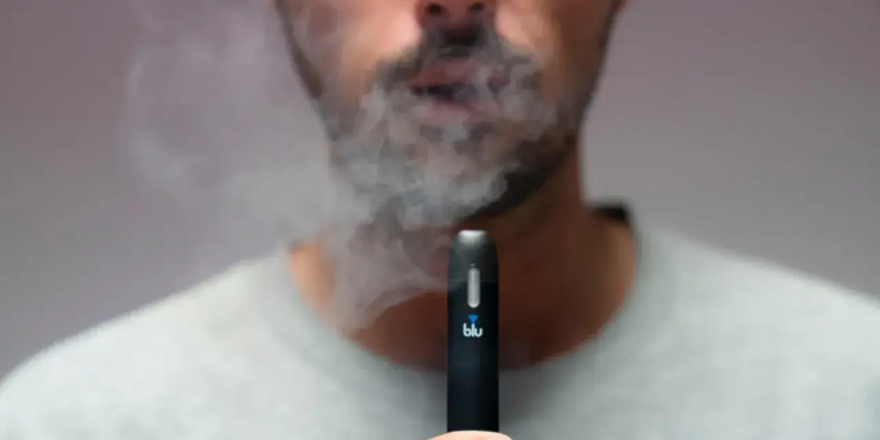 Hombre exhala humo de un vaper blu. Este vaper blu es malo para la salud.