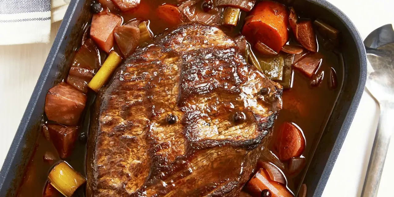 Herzhaftes Rinderbratenstück in dunkler Sauce mit Karotten und Lauch, perfekt für festliche Schmorgerichte an Weihnachten.