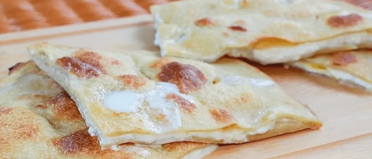 Focaccia di Recco, sottile e dorata, con il suo ripieno filante di formaggio fresco.